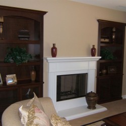 Custom cabinetry built into niches next to fireplace.
