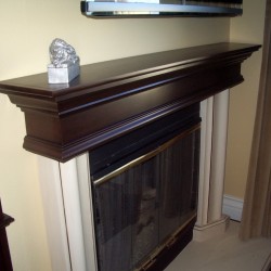Wood fireplace mantel matches built in book shelves.