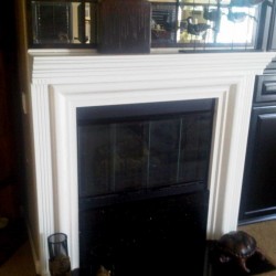 Wood fireplace mantel finished in white lacquer.