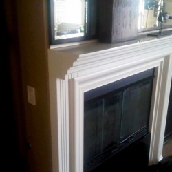 Wood fireplace mantel finished in white lacquer.