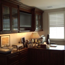 Custom home office design for a stock broker with a built in tv.