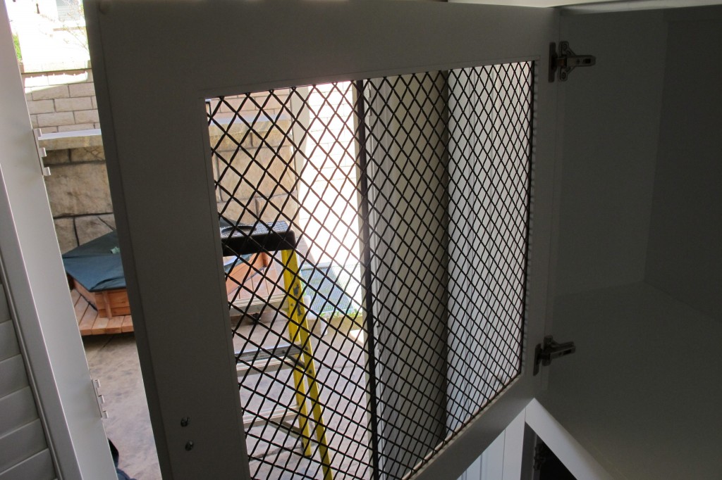 Dog kennel built into white wall wall unit