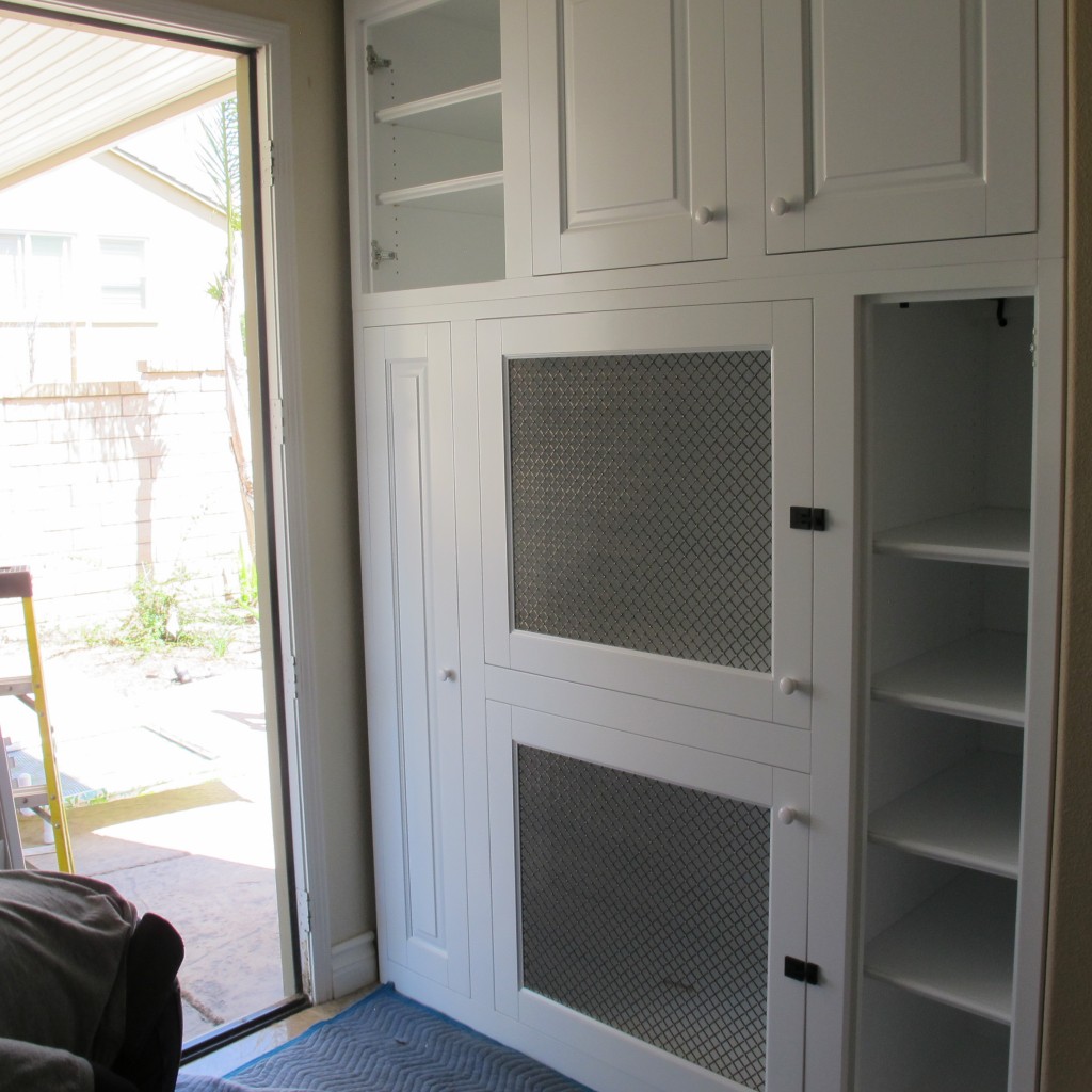 Dog kennel built into white wall wall unit