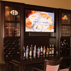 This custom bar includes Lattice wine area, inverted glass sliders, bottle riser and upper display area designed with with both husband and wife present